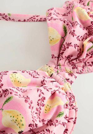 Rosa tyg med ett blommönster som har gula citroner och gröna blad, samlat i en volangdesign med en mjuk textur.