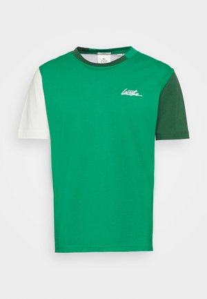 Grünes Baumwoll-T-Shirt mit einem farblich gestalteten Design, weißen und dunkelgrünen Ärmeln sowie einem runden Halsausschnitt, mit dezentem Logo auf der Brust.