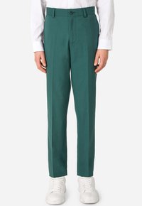 Pantaloni di colore teal realizzati in un materiale liscio, con taglio dritto, due tasche frontali e chiusura a bottone, abbinati a sneakers bianche.