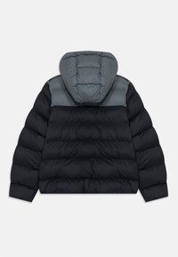 Doudoune avec col montant, présentant un corps noir et des accents grisés sur les épaules, texture lisse et design matelassé.
