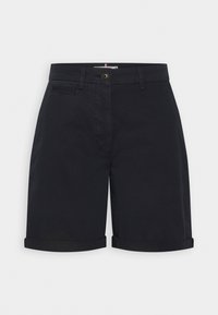 Short noir sur mesure longueur genou avec revers roulés, fermeture par bouton, passants de ceinture et petite poche avant horizontale.