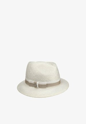 White woven fedora hat with a beige and cream ribbon band and a small round metallic logo tag on the side.