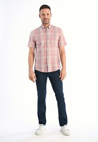 Korte mouwen geruite shirt in roze en blauwe tinten, met knoopsluiting. Draagt met donkere jeans en witte sneakers, wat een casual uitstraling creëert.