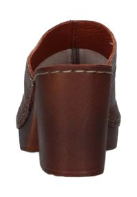 Zoccolo in pelle marrone con punta arrotondata, tacco in legno marrone e cuciture bianche lungo il lato. Texture liscia con un design semplice.