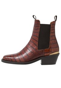 Botte de cheville marron à effet croco avec des côtés élastiques et un petit talon, présentant un design épuré et une finition brillante.