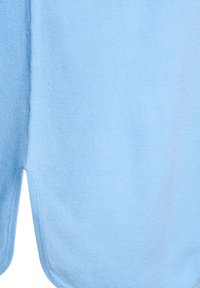 Helehall sinine fliiskangas pehme tekstuuriga, millel on ümar serv ja külje lõhikud liikumise hõlbustamiseks.