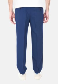 Pantaloni blu navy realizzati in tessuto dalla superficie liscia, dotati di due tasche posteriori con bottone e un fit morbido.
