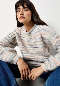 Wielokolorowy sweter o fakturze z okrągłym dekoltem. Posiada paski w pastelowych odcieniach, z miękkim, przytulnym splotem i prążkowanymi mankietami.