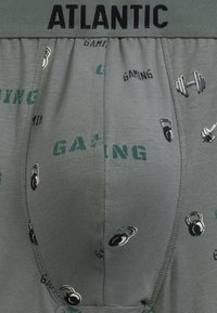 Szare bokserki z elastycznym pasem z napisem "ATLANTIC." Posiadają graficzny nadruk ciężarów oraz słowo "GAMING" w kolorze zielonym.