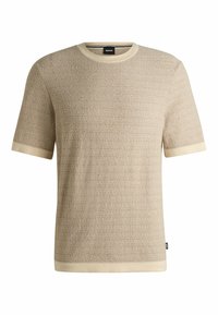 T-shirt beige a maniche corte con texture e un sottile motivo a righe, colletto e bordi delle maniche in crema a coste. Etichetta del marchio visibile.