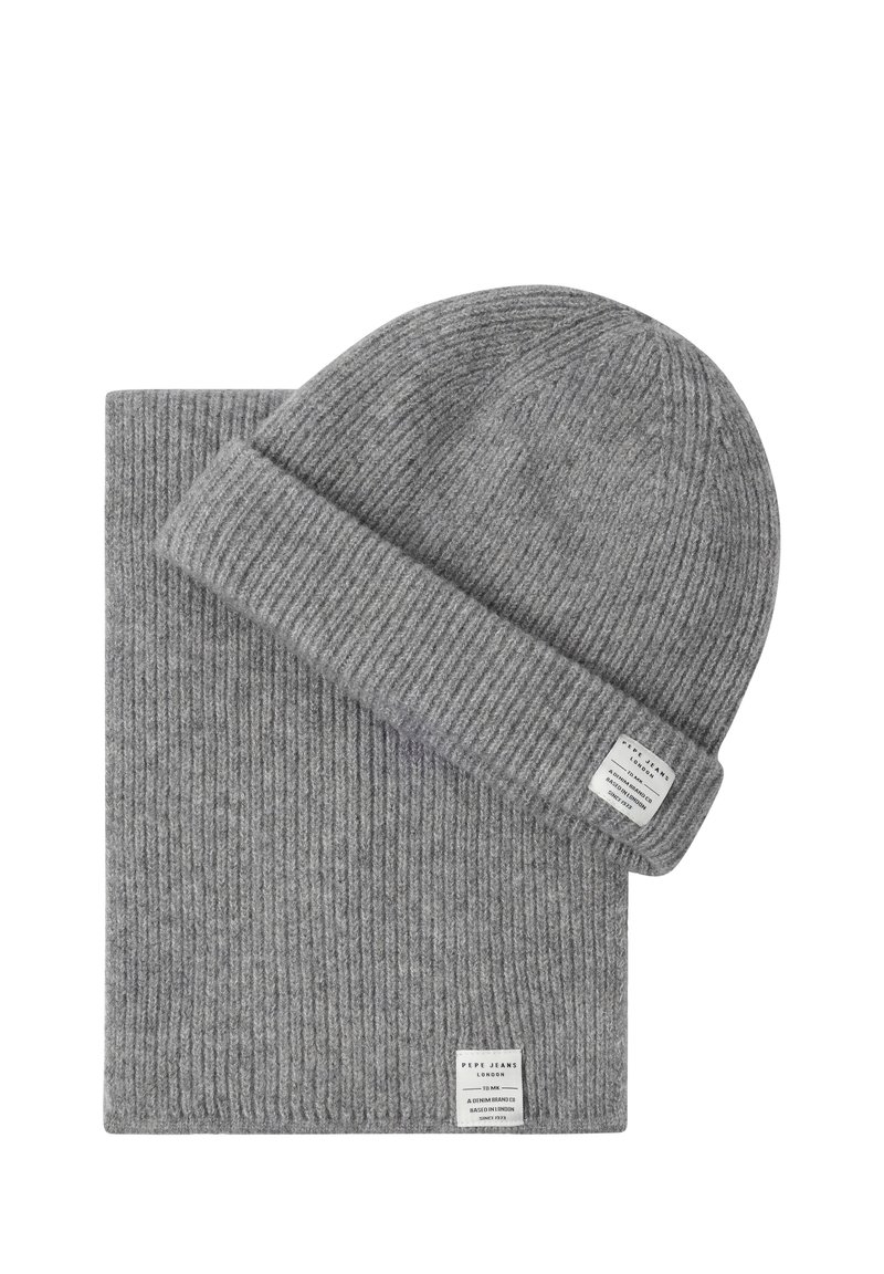 Grå ribbestrikket lue og matchende skjerf-sett, hver med en liten hvit merkeetikett sydd på kanten.