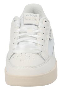 Vita lädersneaker med en slät yta, perforerad tå för andningsförmåga, platta snören och en krämfärgad gummisula. Logotyp på tungan och sidan.