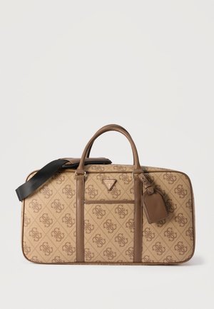 Sac de voyage beige et marron à motif, avec deux poignées, une poche avant, une étiquette pour bagages et une bandoulière noire détachable.