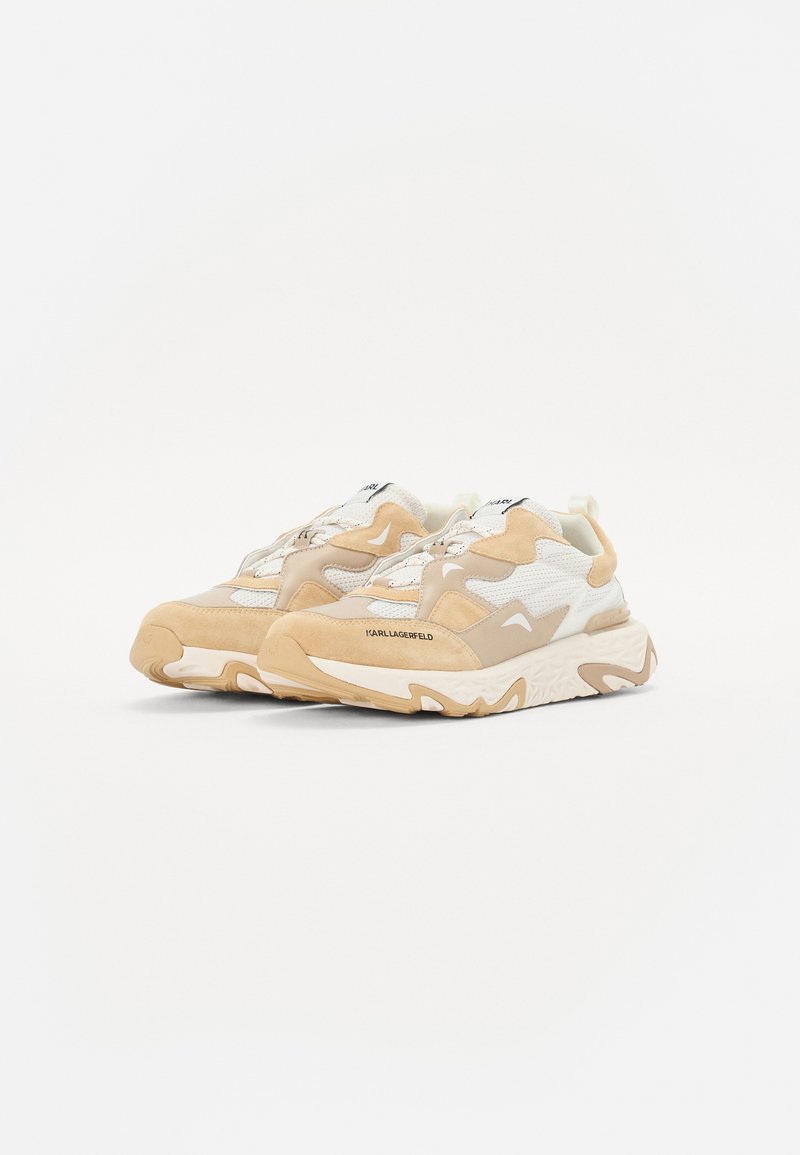 Chunky Sneaker aus beigem und weißem Mesh und Wildleder. Sie verfügen über eine strukturierte Sohle, einen gepolsterten Kragen und Schnürsenkel. Markennamen an der Seite.