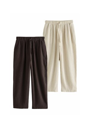 Two pairs of textured, loose-fit drawstring pants, one in dark brown and one in light beige, shown side by side on a white background.