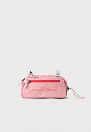 Ροζ ορθογώνια τσάντα μέσης με κόκκινο φερμουάρ, γκρι λουριά και λογότυπο «Peak Performance» στο μπροστινό μέρος, τοποθετημένη σε απλό φόντο.