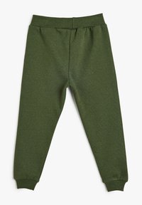 Grüne Baumwoll-Sweatpants mit einer glatten Textur, elastischem Bund und elastischen Bündchen an den Knöcheln. Sie sind einfarbig und haben minimale Details.