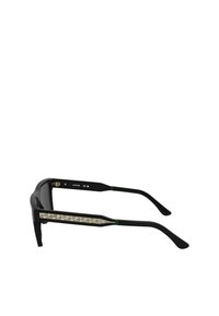 Ochelari de soare negri cu o ramă rectangulare, având accente aurii texturate pe brațele laterale și detalii verzi aproape de balamale.