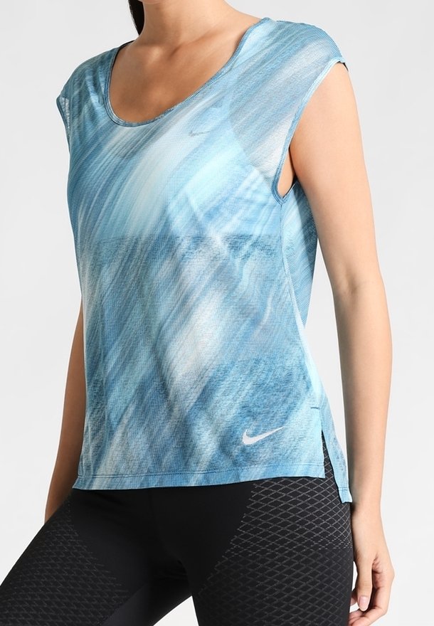 Světlé modré sportovn í tričko s texturovaným vzorem, krátkými rukávy, kulatým výstřihem a bočními rozparky, s malým logem Nike na přední straně.