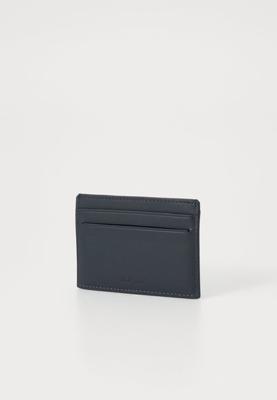 Marinblå läderkortfodral med en slät yta, två kortfack och en minimalistisk design med kontrasterande sömmar. Kompakt och funktionell.
