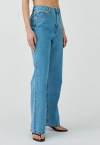 Jeans de corte alto en azul claro, elaborados en denim, con un diseño de pierna recta, un ligero desgastado y el clásico estilo de cinco bolsillos.