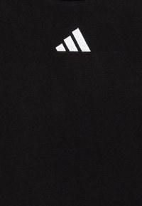 T-shirt en coton noir avec un petit logo en broderie blanche à trois bandes sur la partie supérieure gauche de la poitrine, au toucher lisse.