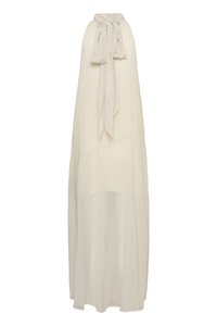 Μακριά αμάνικη κρεμ φόρμα με μικρές μαύρες πουά και ψηλό γιακά δεμένο μπροστά σε φιόγκο.