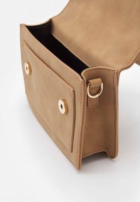 Borsa in finta pelle marrone chiaro con chiusura a scatto dorata, caratterizzata da una tasca frontale e dettagli cuciti lungo i bordi. L'interno è nero.