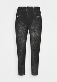 Jeans de denim negro con una textura desgastada y rasgada, que presentan un cierre de botón, trabillas para cinturón y bolsillos delanteros y traseros.