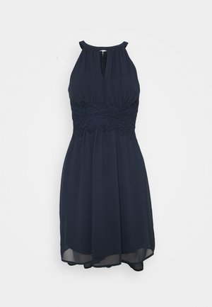 Robe sans manches bleu marine avec encolure halter et détail en dentelle à la taille, longueur genou avec tissu fluide et ouverture clé devant.
