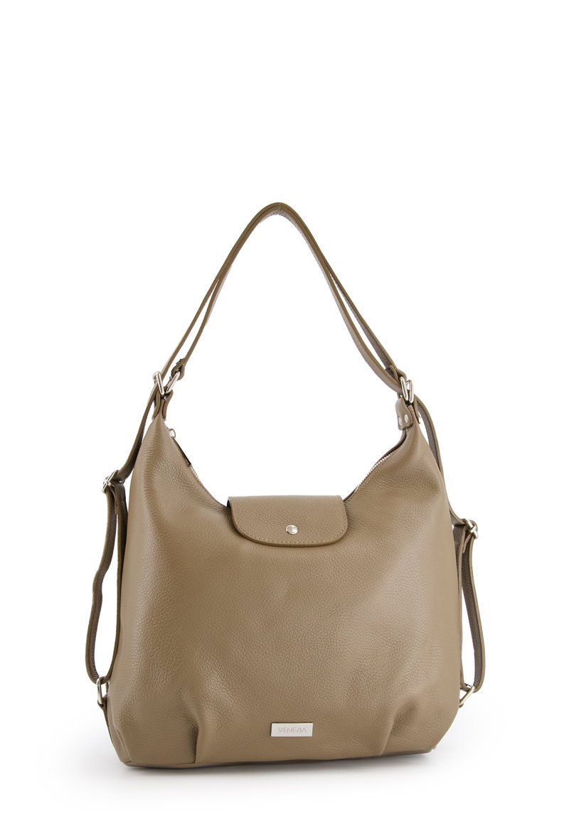 Tan leren handtas met een gladde textuur, een ronde vorm, een voorklep met druksluiting en een verstelbare strap. Zilver kleurige merklabel zichtbaar.