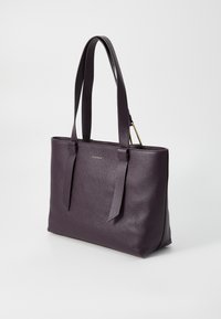 Purple leather tote bag with dual handles, textured finish, and a gold accent. Features a sleek, rectangular shape and minimalistic design.