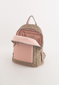 Ryggsäck med en beige mönstrad utsida och detaljer i rosa läder. Har dragkedjestängning och en innerficka med en slät rosa foder.