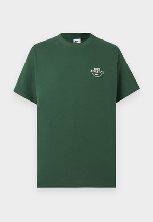 T-shirt vert foncé à manches courtes Nike avec logo "Nike Athletics" blanc et swoosh sur le côté gauche de la poitrine, sur fond uni.