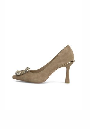 Scarpa con tacco alto in suede beige, con punta affilata, caratterizzata da un accento metallico decorativo nella parte anteriore e un tacco sottile.