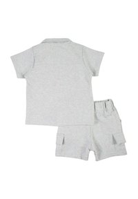 Polo gris en coton à manches courtes et short cargo assorti. Le short est doté de poches latérales et d'une ceinture élastique.