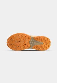 Orange gummisul med triangulära greppknoppar, med en slät central del och "Saucony"-logotypen präglad i mitten.