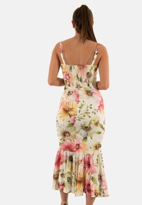 Abito midi floreale con corpetto aderente, spalline regolabili e orlo arricciato. Il materiale presenta grandi motivi floreali colorati.