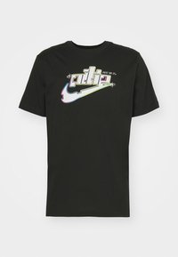 Camiseta de algodón negra con un gráfico colorido del logo de Nike y el texto "JUST DO IT." Manga corta, diseño de cuello redondo, ajuste estándar.
