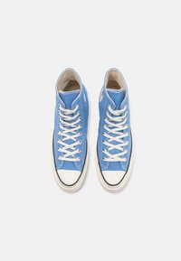 Sneaker alte in tela azzurro chiaro, con lacci bianchi, suole in gomma nera e un classico puntale bianco.