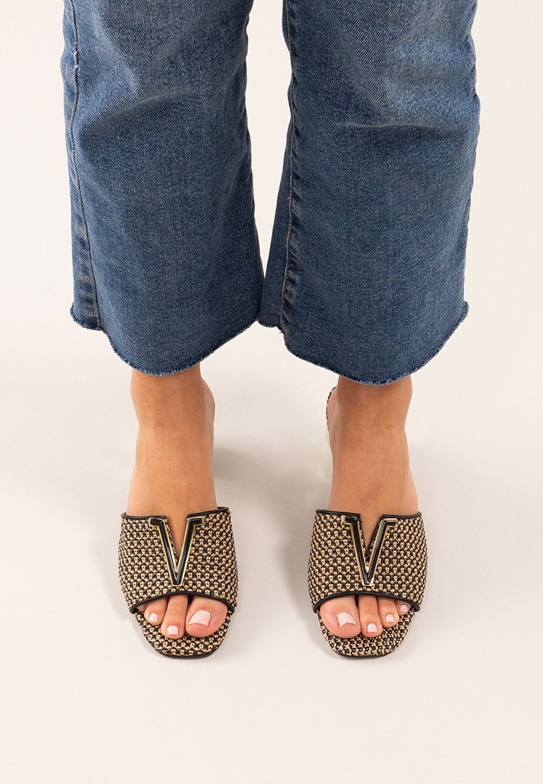 Chanclas beige con parte superior trenzada, diseño en forma de V, ribete negro y punta abierta. Superficie texturizada y suela plana.