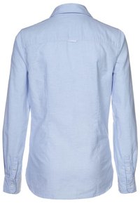 Ljusblå långärmad skjorta med klipskrage, ryggrynna och manschetter med knappdetaljer. Tillverkad i ett strukturerat tyg.