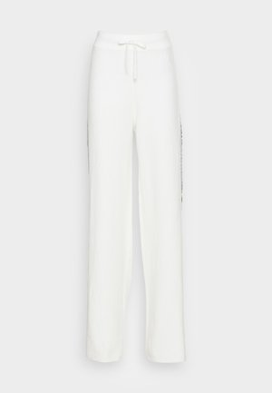 White wide-leg sweatpants with a textured finish, featuring an elastic waistband and drawstring, adorned with black side accents.