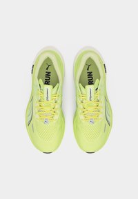 Ζεύγος απλών παπουτσιών τρεξίματος Puma σε νέον κίτρινο χρώμα με μαύρο λογότυπο Puma, ανθεκτικό διχτυωτό επάνω μέρος και κείμενο "RUN" στις εσωτερικές σόλες, φαίνεται από πάνω.