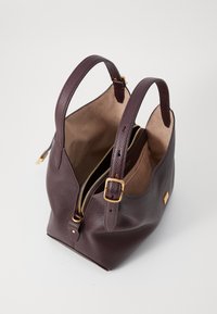 Violet odinė rankinė su tekstūruotu paviršiumi, dviem rankenomis, auksinėmis detalėmis ir užtrauktuku. Erdvus vidus su lygiu pamušalu.