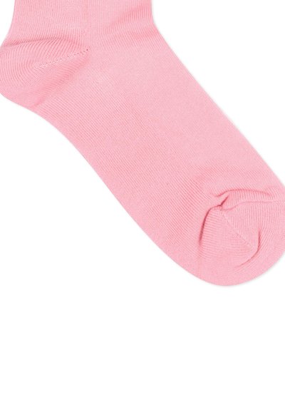 Chaussette cheville rose pâle avec manchette côtelée et texture en maille lisse, présentée sur un fond blanc.