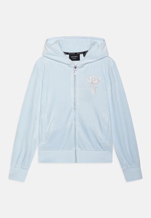 Sweat à capuche zippé en velours bleu clair avec une capuche, orné d'un dessin de couronne et de la lettre "J" en cristaux scintillants sur la poitrine. Manches longues, poches avant.