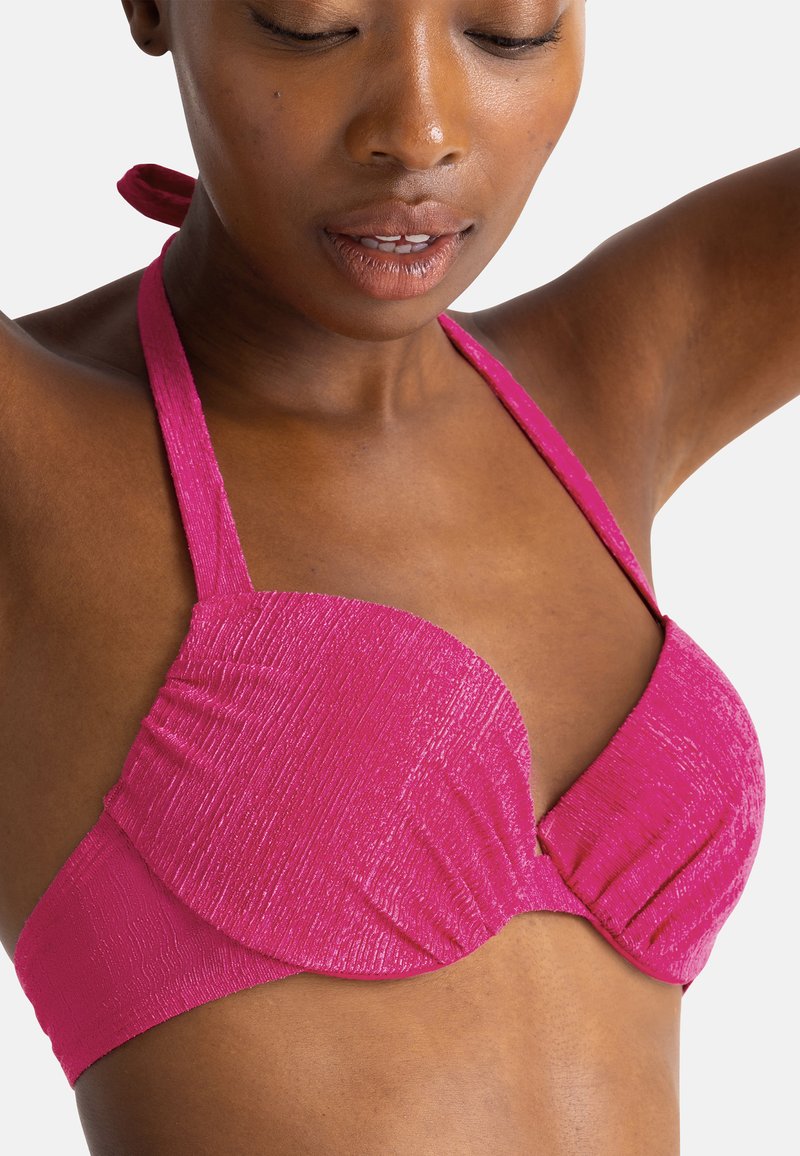 Rožinis tekstūruotas bikini viršus su paminkštintais puodeliais, kaklo nusirišimu ir susiraukšlėjimais šonuose formai ir atramai. Lygi paviršiaus apdaila.