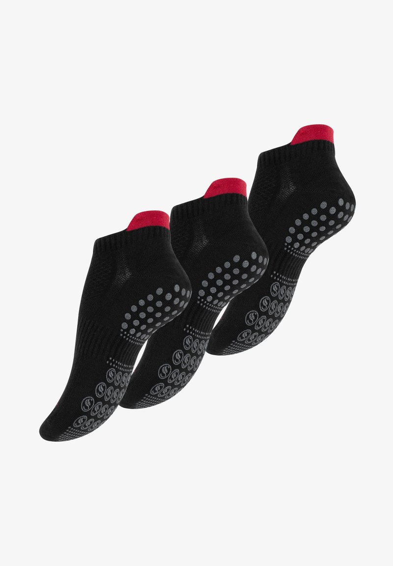 Chaussettes noires à la cheville avec des accents rouges et des motifs de grip en silicone sur les semelles pour une meilleure adhérence. Conçues pour le confort et la stabilité.