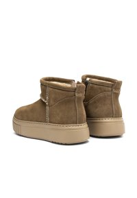 Botas de ante marrón hasta el tobillo con un acabado texturizado, cremallera lateral y suela de goma beige. Presenta detalles de costura a lo largo de las costuras.